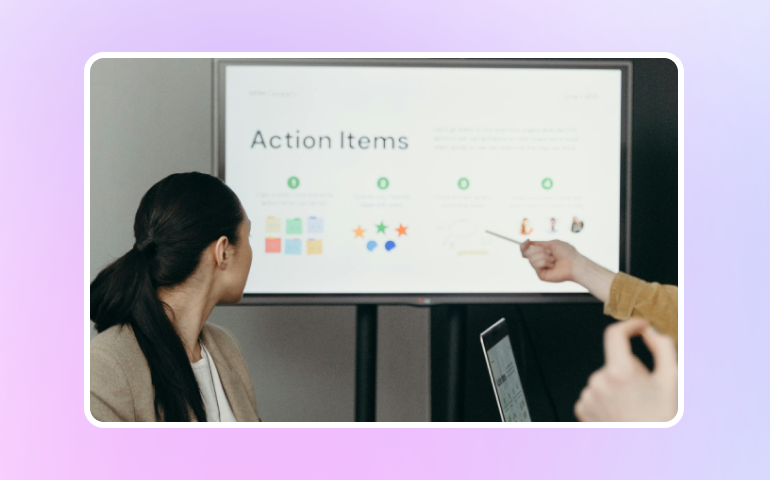 Women looking at a action items board